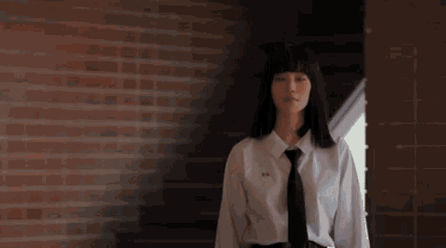 the girl is wearing a white shirt and black tie .