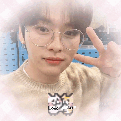 a close up of a person wearing glasses and a sweater that says liv3 minho