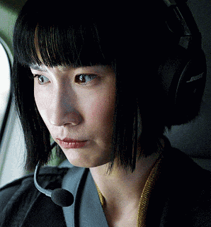 a close up of a woman wearing bose headphones and a microphone