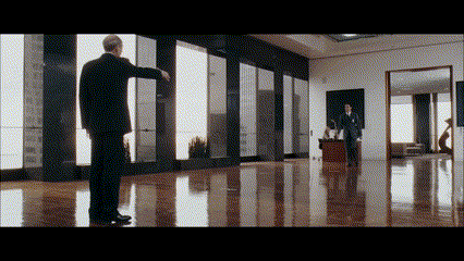 a man in a suit is standing in front of a large window