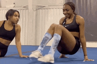 two women are doing exercises together on a blue mat .
