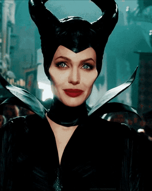 a close up of a woman wearing horns and a black costume