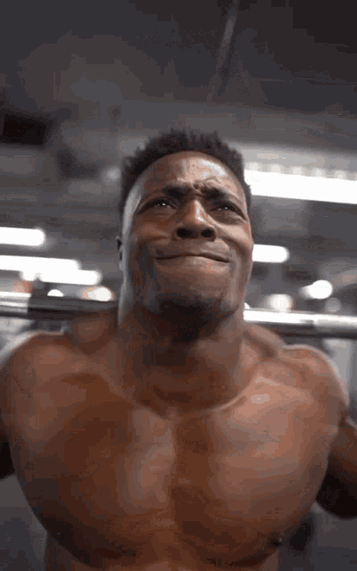 a man without a shirt is squatting with a barbell on his shoulders