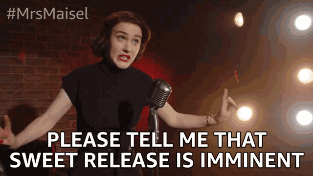 a woman stands in front of a microphone with the words please tell me that sweet release is imminent below her