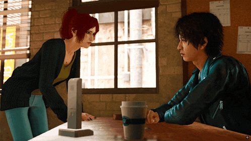 a man and a woman are sitting at a table with a cup that says ' coffee ' on it