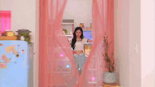 a woman in a white crop top and blue pants is surrounded by pink stars and a pink heart