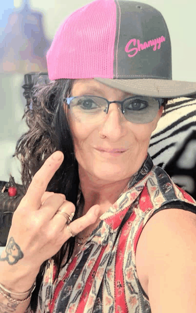 a woman wearing a pink and gray hat that says shanya