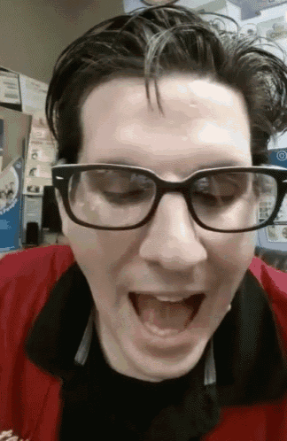 a man wearing glasses is making a funny face with his mouth open
