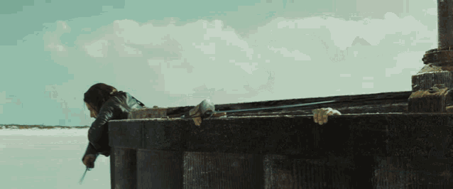 a man with a beard is leaning over a barrel