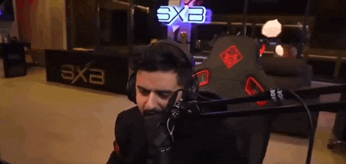 a man wearing headphones is sitting in front of a microphone in a room .