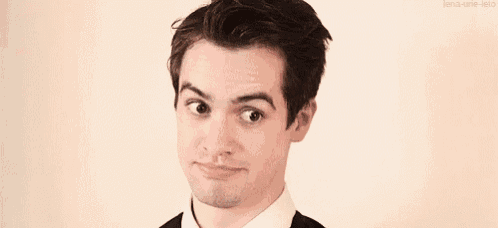 a man in a suit and tie is making a funny face with his eyes closed .