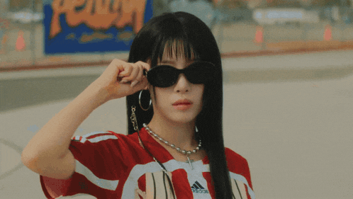 a woman wearing sunglasses and a green bandana has a necklace that says i love you