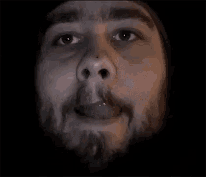 a close up of a man 's face with his mouth open
