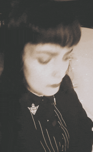 a black and white photo of a woman wearing a striped shirt and a brooch