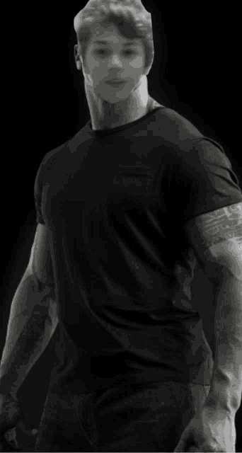 a black and white photo of a man with a tattoo on his arm