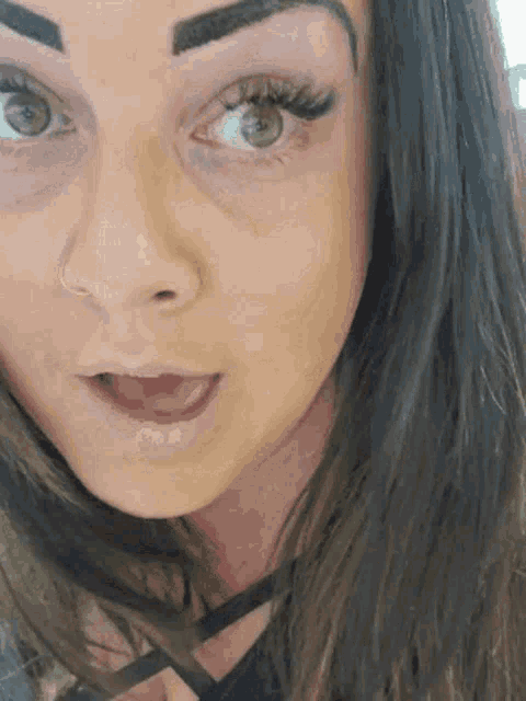 a close up of a woman 's face with a nose ring
