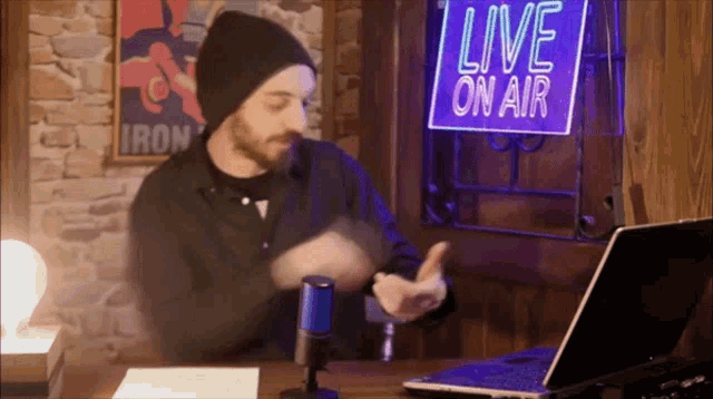a man is standing in front of a live on air sign