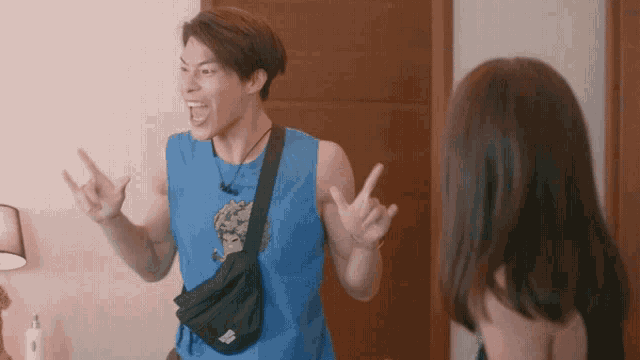 a man wearing a blue tank top with a hulk on it is yelling at a woman
