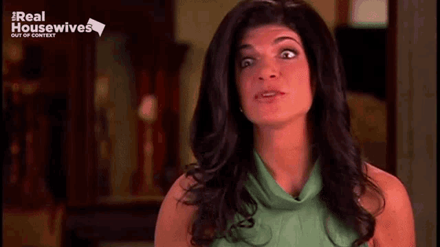 a woman is making a funny face while wearing a green shirt .