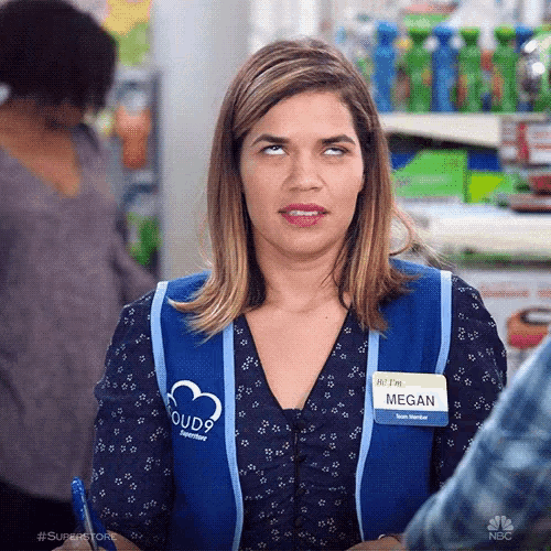 a woman in a blue vest is making a funny face .