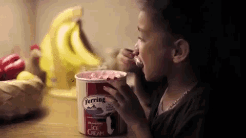 a young girl is eating ice cream from a ferris ice cream container