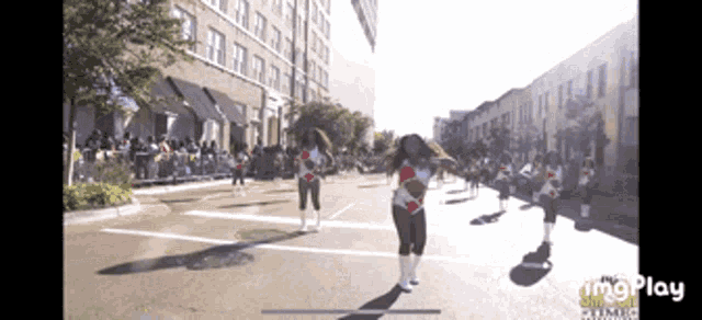 a group of people marching down a street with the word imgplay at the bottom of the screen