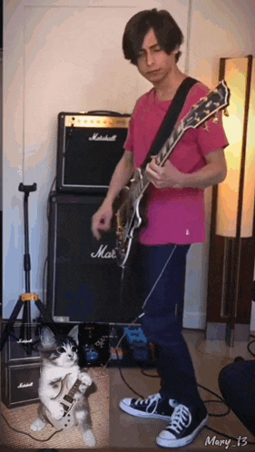 a man in a pink shirt is playing a guitar in front of a marshall amp