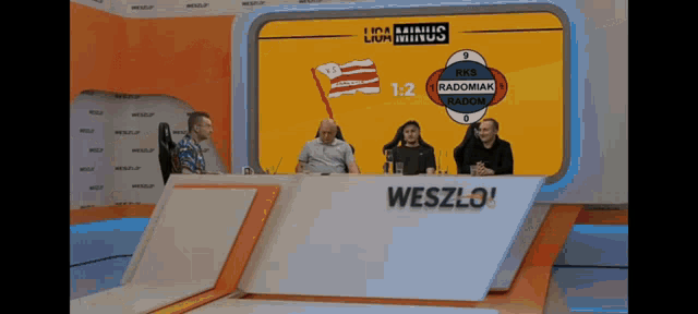 a group of people sitting in front of a screen that says ' liga minus ' on it