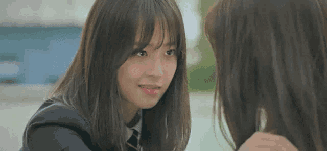 two girls are looking at each other and one of them is wearing a pink lipstick .