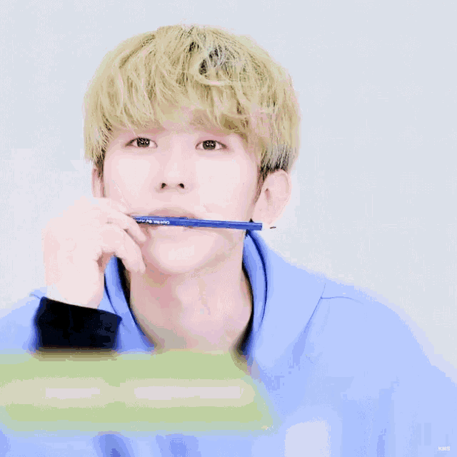 a close up of a person holding a pencil in their hand