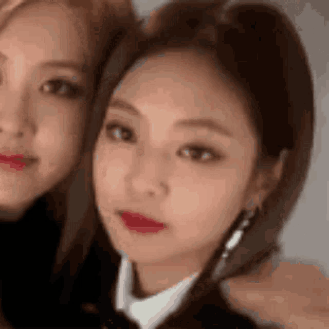 two women are posing for a picture together and one has red lipstick on her lips