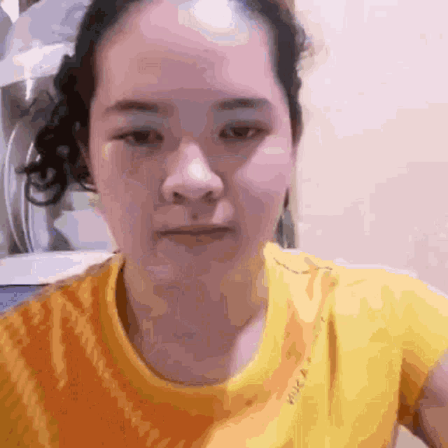a close up of a woman 's face with a yellow shirt that says nike on it