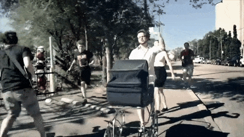 a man in a wheelchair is being pushed down the street