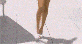 a woman in a blue bikini is walking on the sidewalk