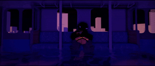 a person sits on a couch in a dark room with a purple background