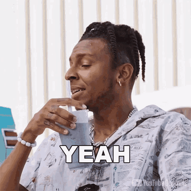 a man drinking from a plastic cup with the word yeah written on it