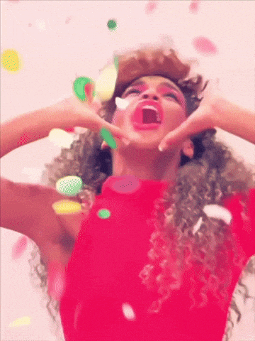 a woman in a red sweater is surrounded by confetti