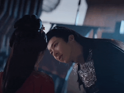 a man and a woman are looking at each other and the woman is wearing a red dress