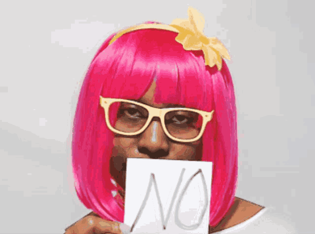 a woman in a pink wig and glasses holds a sign that says no