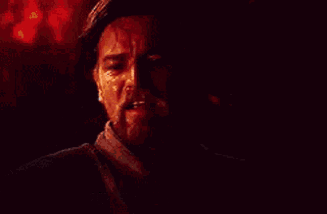 a man with a beard is standing in a dark room .