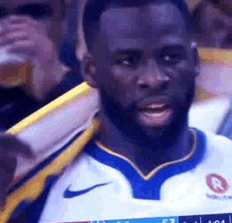 a man with a beard is wearing a nike jersey while watching a game .