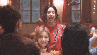 a woman is holding a piece of chicken in her mouth while standing next to a group of people .