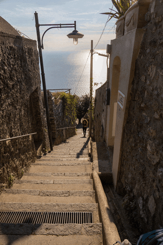 a person walking down a set of stairs with a sign on the wall that says no parking