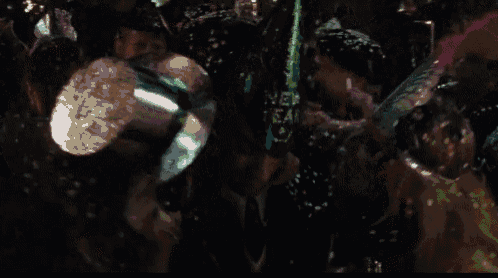 a crowd of people are gathered in a dark room with a green item that says " never fear "