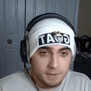 a man wearing headphones and a white beanie with the word ta on it .