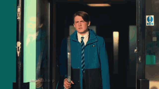 a man in a blue jacket and tie is standing in front of a door that says " amanda.haap "