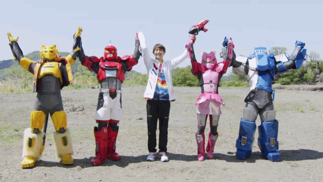 a group of robots standing next to each other with a man in the middle holding a gun