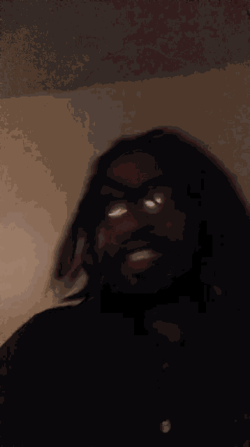 a blurry picture of a man wearing glasses and dreadlocks