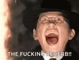 a man in a top hat and glasses is screaming with his mouth wide open .