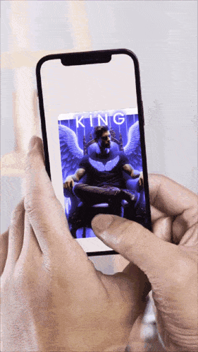 a person is holding a phone with a picture of a man with wings on it